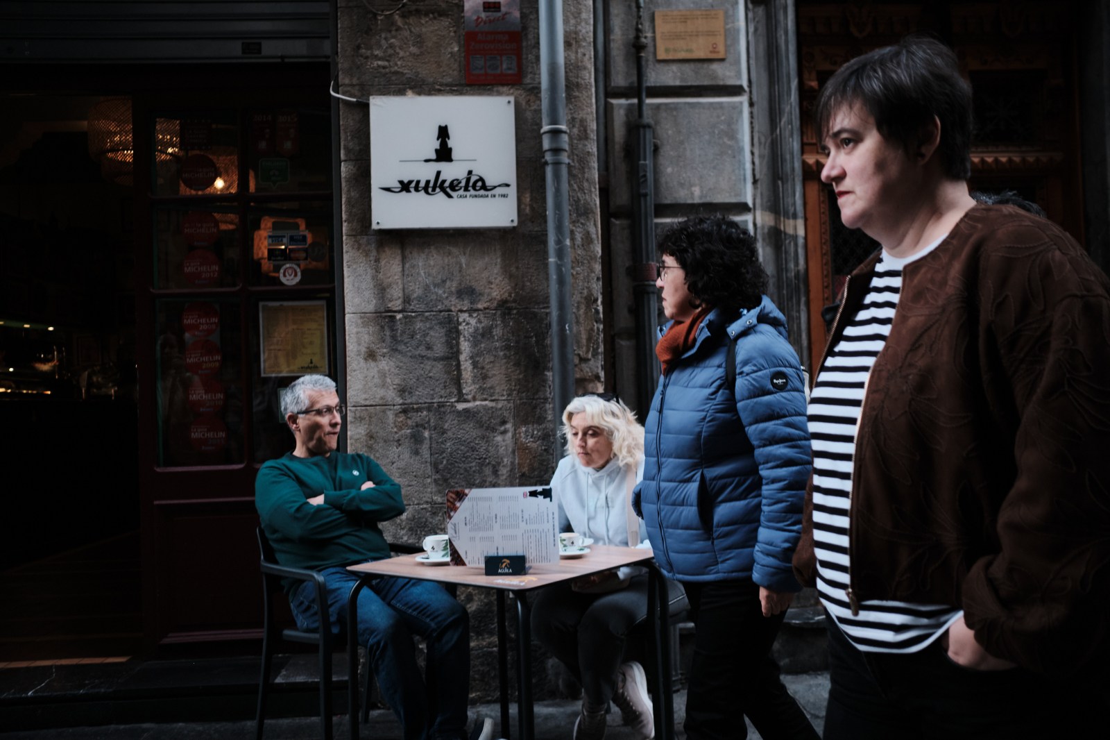 Dos personas sentadas en una terraza callejera durante el taller de street photography en Bilbao de Rober Tomás.