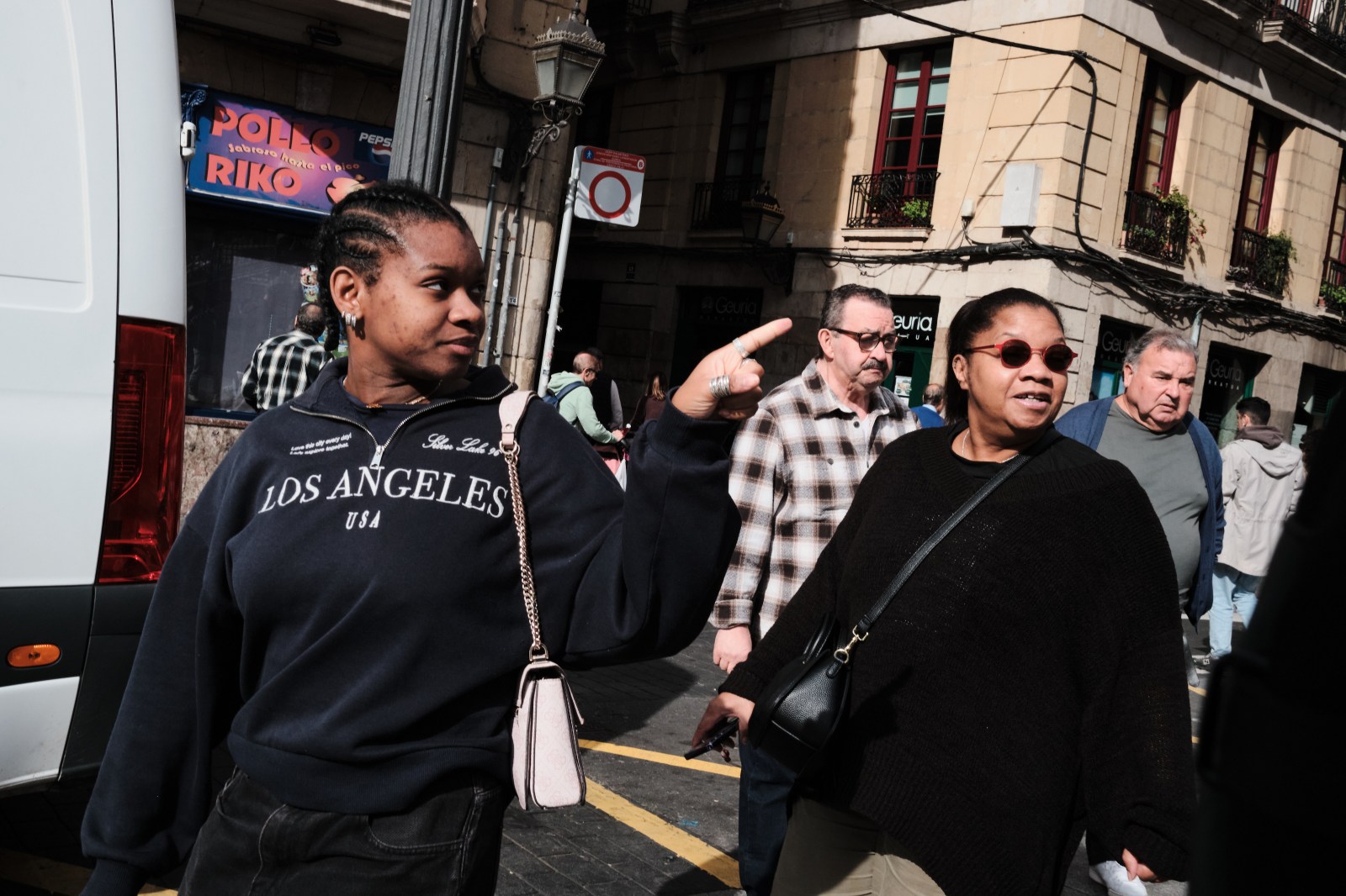 Persona caminando por una calle concurrida con ambiente otoñal en Bilbao.