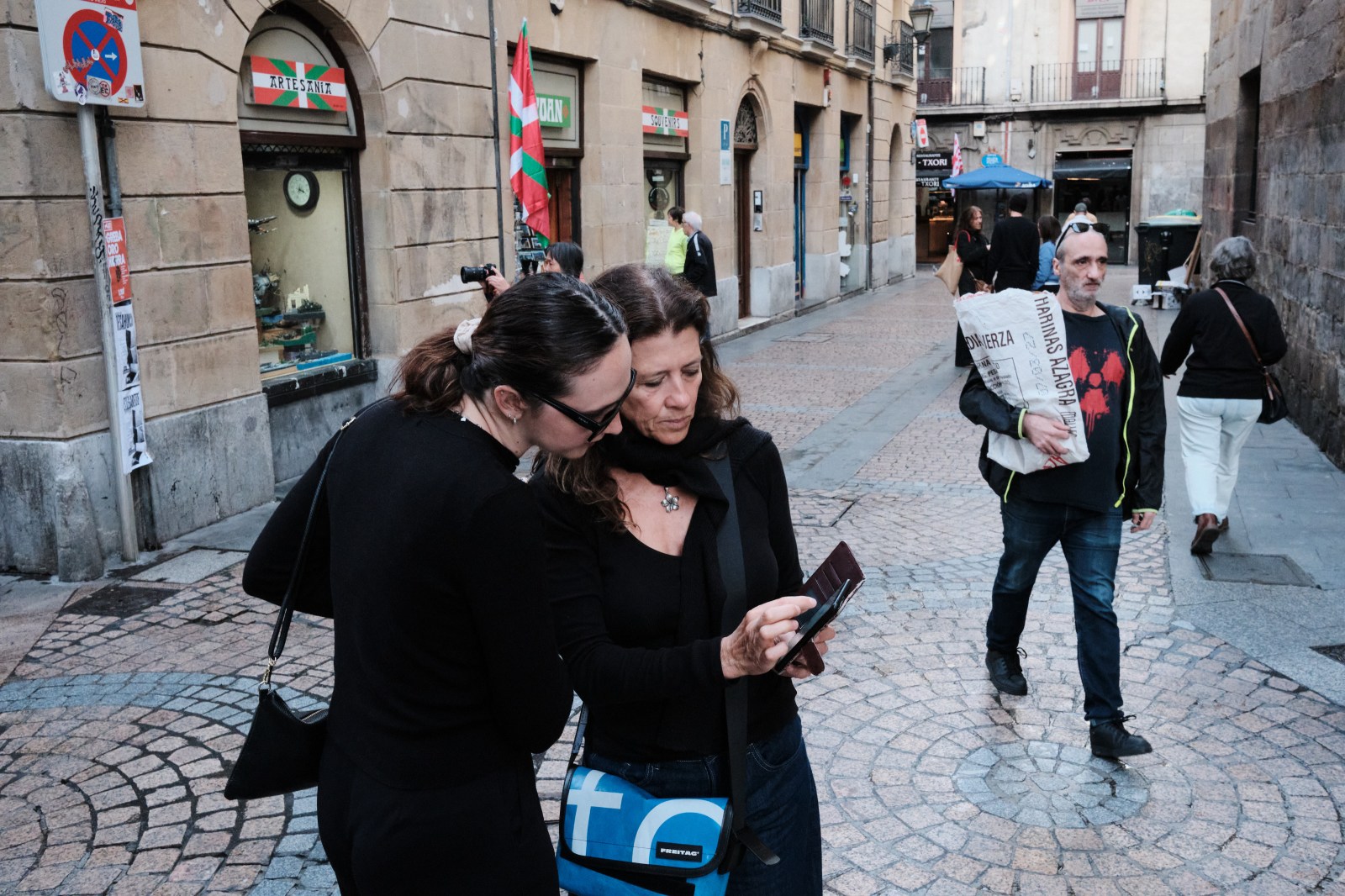 Grupo de personas interactuando en una calle céntrica durante la práctica fotográfica.