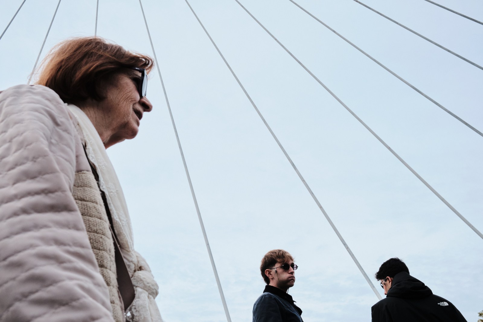 Siluetas de personas recortadas frente al cielo despejado junto a elementos arquitectónicos.