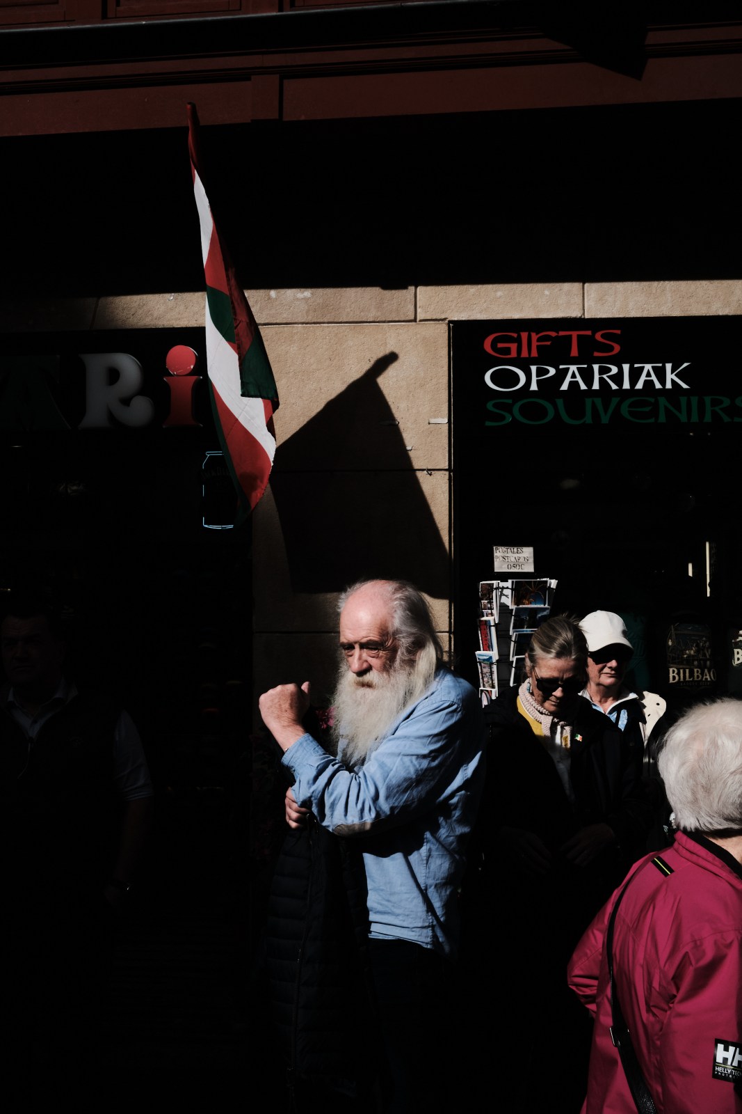 Fotografía documental de un grupo reunido bajo banderas en un espacio público de Bilbao.