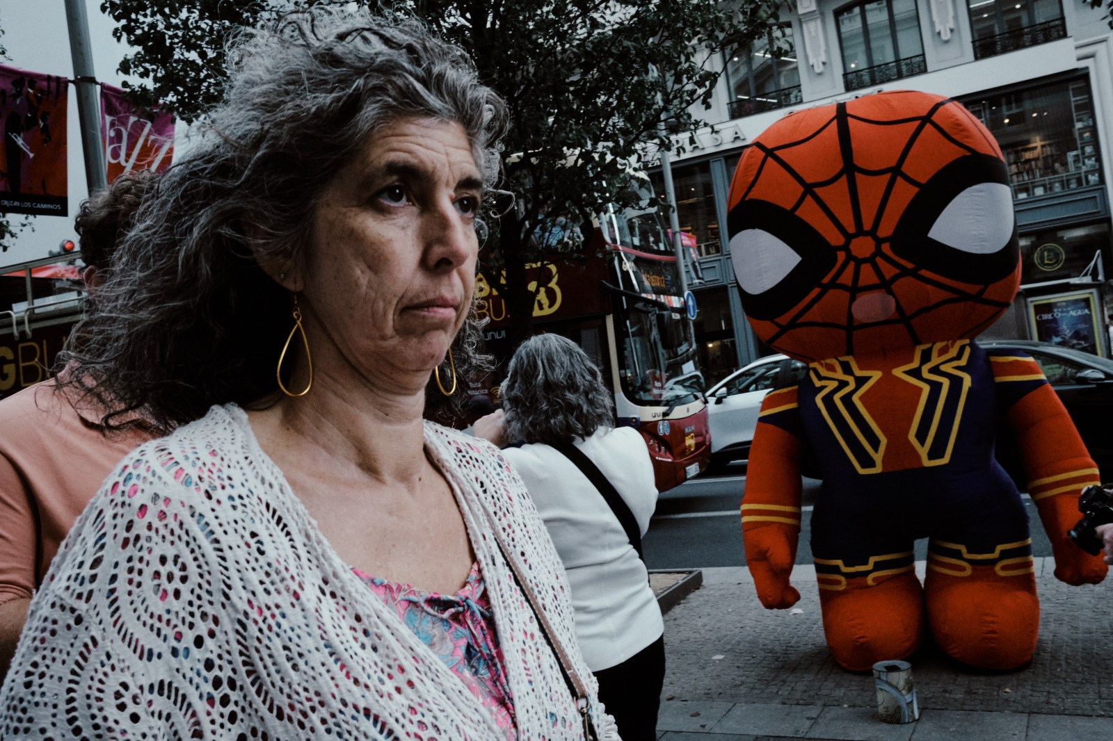 Taller de Inmersión en Fotografía de Calle en Madrid con Rober Tomás. Una mujer que pasa delante de un muñeco gigante de Spiderman en Gran Vía