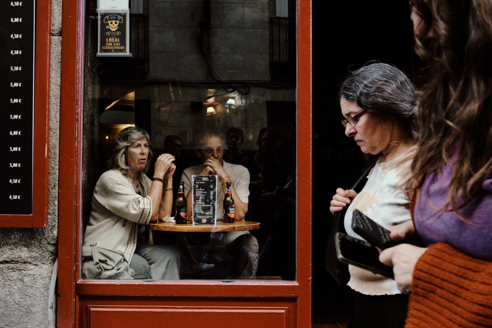 Taller de Inmersión en Fotografía de Calle en Madrid con Rober Tomás. Personas pasando por la calle delante de un restaurante pintado de rojo
